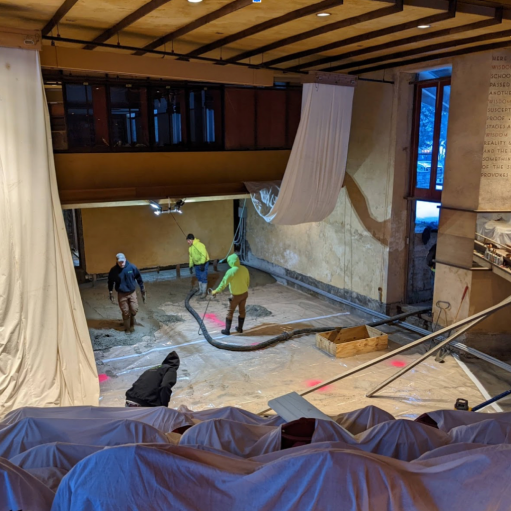 The preservation team pouring concrete in the theater.