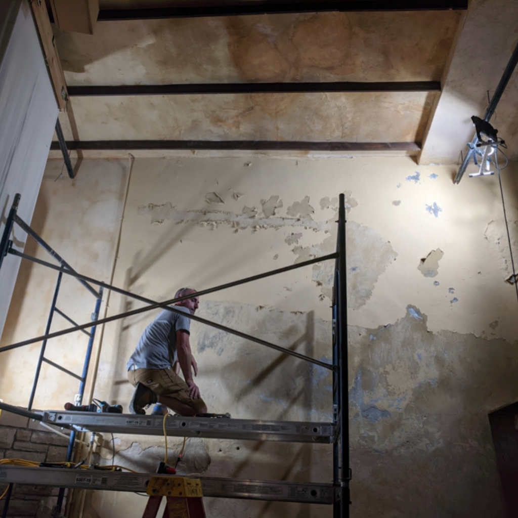 Photo of preservation team repairing the plasterwork on a theater wall. 